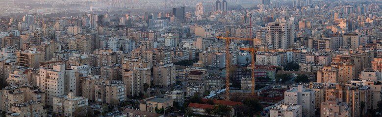 Fototapeta na wymiar Aerial panoramic view of a residential neighborhood in a city during a vibrant and colorful sunrise. Taken in Netanya, Center District, Israel.