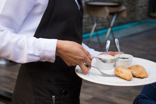 Mesera sirviendo empanadas 