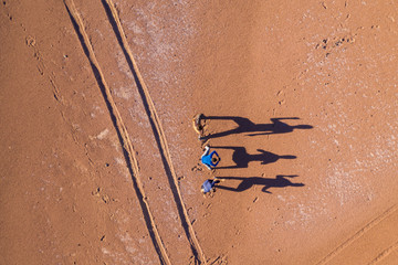 Aerial view real people playing with its shadows during sunrise at Atacama Desert campsite. Amazing...