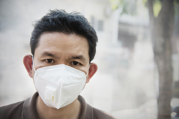Man wearing mask protect fine dust in air pollution environment - people with protection equipment...