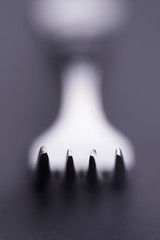 Vertical isolated fork concept with bokeh on black and white style