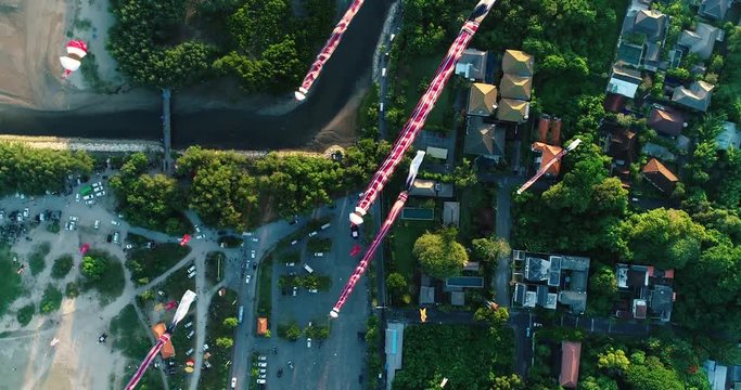 Aerial shot traditional Balinese kites soaring in the air above seaside at sunset, Sanur, Bali, Indonesia. 4K