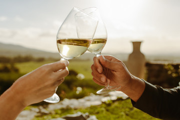 Couple toasting white wine in a vine yard - Powered by Adobe