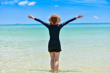 Obraz premium Women standing on sea beach blue sky background Travel in Summer Holidays