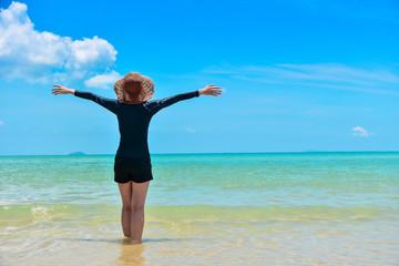 Obraz premium Women standing on sea beach blue sky background Travel in Summer Holidays