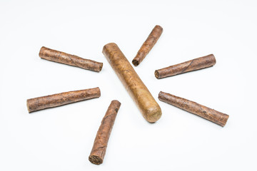 The sun laid out of twisted cigars on white background.