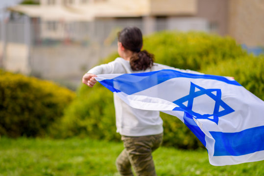 Happy Girl running with Israel flag. Image to illustrate election win, patriotic holiday Independence day Israel - Yom Ha'atzmaut concept.