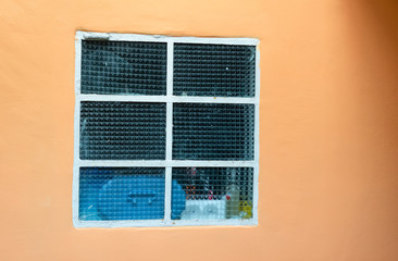ventana con vidrios martillados. fondo de pared color naranja