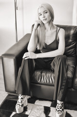 Black and white portrait of a blonde lady sitting in an armchair