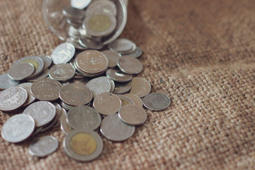 Saving money, Thai money in the glass on the sack of brown background