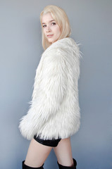 Beautiful lady dressed in white fur coat and black shorts