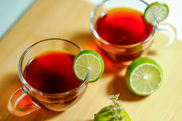 Black tea in cup with lemon