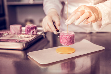 Focused photo on female hands that creating dessert