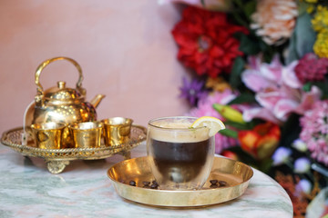 Iced coffee shakerato - A glass of espresso shot mixed with craft soda and orange juice and topped with sliced lemon on table.