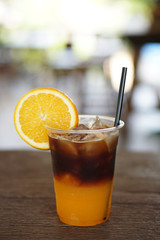 Iced coffee shakerato - A glass of espresso shot mixed with craft soda and orange juice and topped...