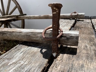 Clavo y argolla viejos y oxidados para fijar carretilla de madera