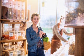 A young woman buying food in an organic food store in bulk