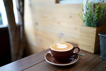 Hot flat white - A cup of coffee with milk and latte art on wooden table background and copy space, Perfect for breakfast time.