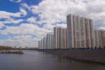 Obraz premium high multi-storey residential buildings on the river Bank