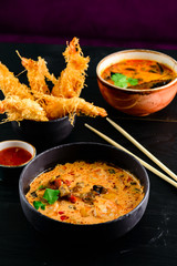 Close up of a bowl of Thai spicy seafood tom yum noodle with shrimp, squid, fish and New Zealand mussel.