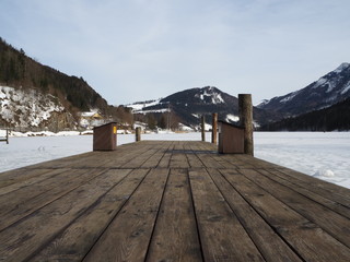 Boat dock in frozen lake in the background mountains