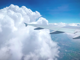 Fototapeta na wymiar Aircraft wing against blue sky from its windows