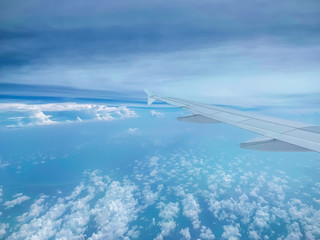 Aircraft wing against blue sky from its windows