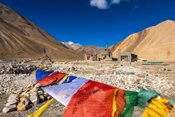 Ruin building and stupa in Leh Ladakh with praying flag on sunny blue sky day.