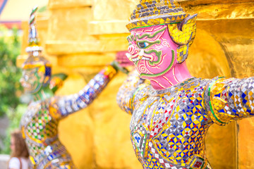 Pink Giants statue under golden pagoda in wat pra keaw , Bangkok , Thailand