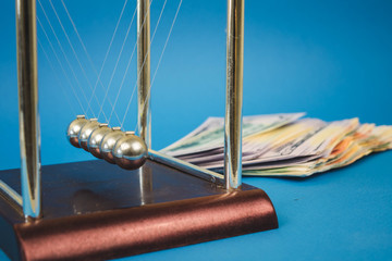 a lot of money dollars and newton balls on a blue background