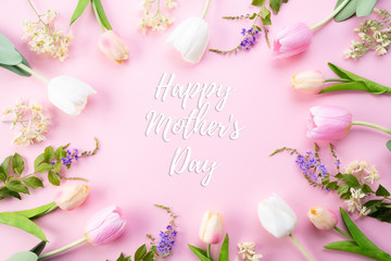 Naklejka na ściany i meble Happy mothers day concept. Top view of pink tulip flowers in frame with happy mothers day text on pink pastel background. Flat lay.