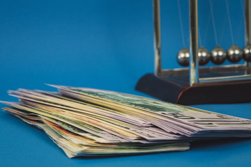 a lot of money dollars and newton balls on a blue background