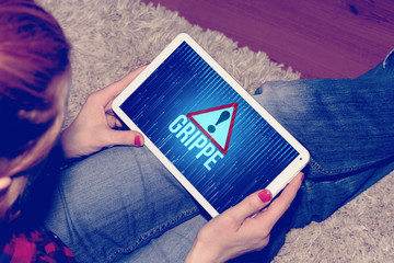 Eine Frau mit Tablet PC und Warnung vor der Grippe