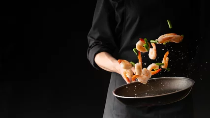 Fotobehang Eten Zeevruchten, professionele kok bereidt garnalen met sprigg bonen. Koken zeevruchten, gezond vegetarisch eten en eten op een donkere achtergrond. Horizontale weergave. Oosterse keuken