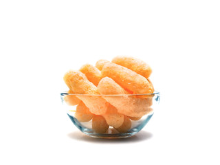 Yellow Corn Puffs in a Glass Bowl Isolated On White Background. Crunchy Flavored Puffed Snacks. Party, Movie, TV, Game Snacks.