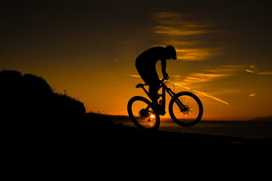 silhouette of cyclist on background of sunset sky