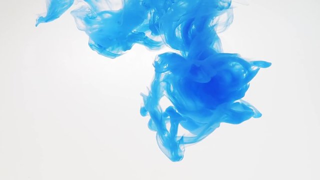 Blue acrylic paint dropped into water and recorded while dissolving, close shot. Blurred background. Abstract swirl of blue paint in liquid. Abstract acrylic splash in water. Ink in water