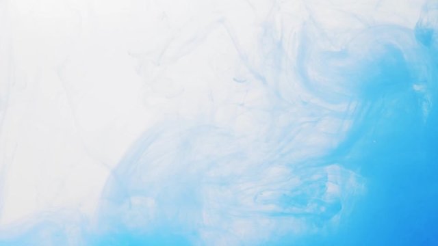 Abstract background of blue paint dissolving into a water, close shot. Blurred background. Abstract acrylic pattern in liquid. Ink movement in liquid. Pattern of blue paint disappearing in water