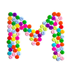 Letter M of the English alphabet made of multi-colored buttons