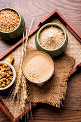 Sattu sharbat is a cooling sweet drink made in summer with roasted black chickpea flour, barley, suger, salt & water. served in a glass. selective focus