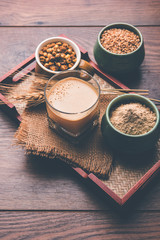 Sattu sharbat is a cooling sweet drink made in summer with roasted black chickpea flour, barley, suger, salt & water. served in a glass. selective focus