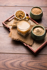Sattu sharbat is a cooling sweet drink made in summer with roasted black chickpea flour, barley, suger, salt & water. served in a glass. selective focus