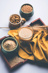 Sattu sharbat is a cooling sweet drink made in summer with roasted black chickpea flour, barley, suger, salt & water. served in a glass. selective focus