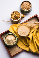 Sattu sharbat is a cooling sweet drink made in summer with roasted black chickpea flour, barley, suger, salt & water. served in a glass. selective focus