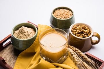 Sattu sharbat is a cooling sweet drink made in summer with roasted black chickpea flour, barley, suger, salt & water. served in a glass. selective focus