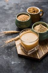 Sattu sharbat is a cooling sweet drink made in summer with roasted black chickpea flour, barley, suger, salt & water. served in a glass. selective focus
