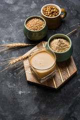 Sattu sharbat is a cooling sweet drink made in summer with roasted black chickpea flour, barley, suger, salt & water. served in a glass. selective focus