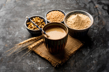 Sattu sharbat is a cooling sweet drink made in summer with roasted black chickpea flour, barley, suger, salt & water. served in a glass. selective focus