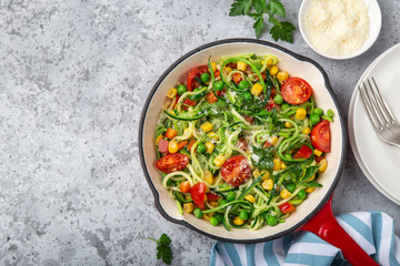 zucchini noodle with tomato, corn and green peas on pan, healthy vegan food