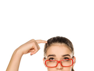 Young woman with glasses scraching her head on white background